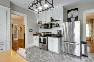 uma cozinha com armários brancos e um frigorífico de aço inoxidável em The Porter Pearl Centrally Located Joplin Home! em Joplin