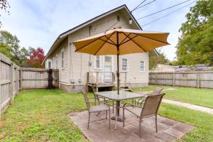 uma mesa e cadeiras com um guarda-sol num quintal em The Porter Pearl Centrally Located Joplin Home! em Joplin