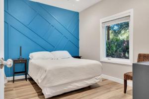 - une chambre avec un lit et un mur bleu dans l'établissement Stylish guest house near colleges, à Claremont