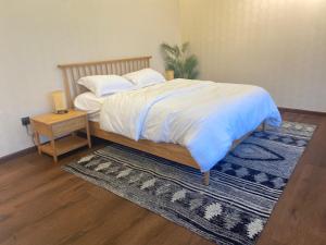 a bedroom with a bed with a rug and a table at منتجع تربل فور - Triple Four Resort in Buraydah