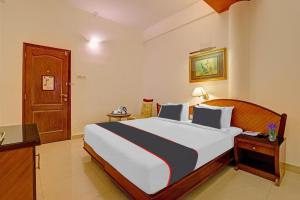 a bedroom with a large bed in a room at Hotel Indraprastha in Trivandrum
