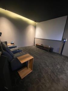 um quarto com um sofá e um ecrã de projecção em منتجع تربل فور - Triple Four Resort em Buraydah