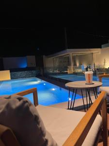uma piscina com uma mesa com uma bebida em منتجع تربل فور - Triple Four Resort em Buraidah