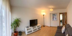Apartamento en Costa de Cantabria, Laredo في لاريدو: غرفة معيشة مع أريكة وتلفزيون
