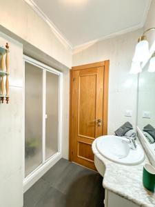 a bathroom with a sink and a glass door at Apartamento en Costa de Cantabria, Laredo in Laredo