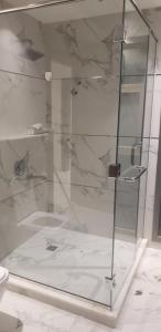 y baño con ducha y puerta de cristal. en Blessed Rest house en Dubái