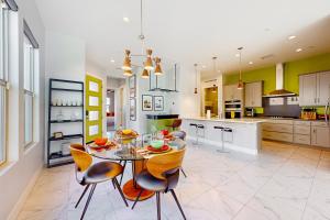 uma grande cozinha com uma mesa de vidro e cadeiras em Desert Cool em Rancho Mirage