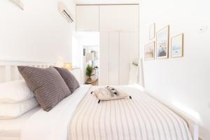 Dream Suite in Como في كومو: غرفة نوم بيضاء مع سرير عليه شنطة