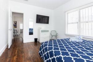 een slaapkamer met een blauw en wit bed en een bureau bij 2 B/R- Heart of South Beach, Near Ocean Dr & Beach in Miami Beach
