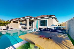 a villa with a swimming pool and a house at Desert Cool in Rancho Mirage