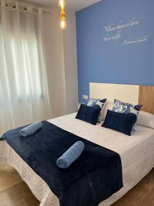 una camera da letto con un grande letto con pareti blu di Apartamentos Jardín Turquesa a Lloret de Mar