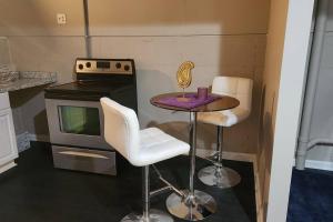 a small kitchen with a table and two stools at Quadruplex Gem:Patio Paradise in Fayetteville