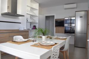 una sala da pranzo bianca con tavolo e sedie bianchi di Apartamento Exclusivo San Marcos a Manzanares