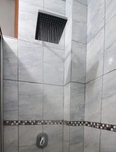 een douche met een grote tegelwand met een afvoer bij Departamento Don Tuquito in Loja