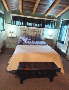 a bedroom with a large bed and two windows at Tres Coronas in San Martín de los Andes