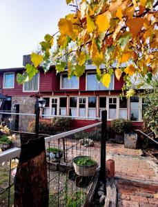 uma casa vermelha com uma cerca em frente em Tres Coronas em San Martín de los Andes