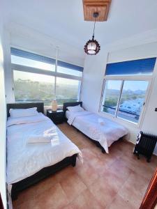 1 dormitorio con 2 camas y ventana grande en oualidia surfhouse, en Oualidia
