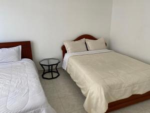 ボゴタにあるStay In Bogotaのベッドルーム1室(ベッド2台、小さなテーブル付)