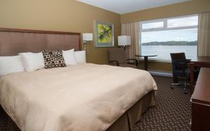a hotel room with a bed and a desk and a window at Inn on the Harbour in Prince Rupert