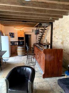 a living room with a chair and a table and a kitchen at Maison familiale avec piscine in Saint-Amand-Montrond