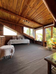 a large room with two beds and windows at Cabañas Temistocles in Esquel
