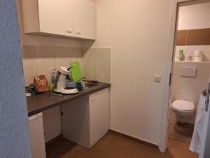 una pequeña cocina con lavabo y aseo en hoteliving Apartments Gießen-Süd, en Giessen