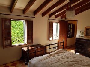 sypialnia z łóżkiem i komodą oraz 2 oknami w obiekcie Can Vives w mieście Binissalem