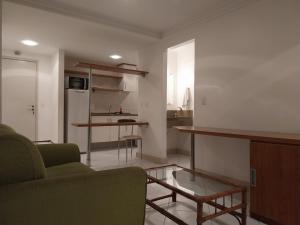 uma sala de estar com um sofá e uma mesa em Flat e Suíte no Via Park - NF e Wi-FI em Campos dos Goytacazes