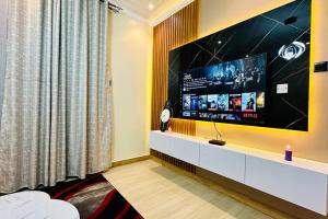 - un salon avec une grande télévision à écran plat dans l'établissement BlackOak Luxury Home B06 1BR Kyanja, à Kampala