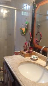 a bathroom with a sink and a large mirror at Loft Jardim Imbassai in Imbassai