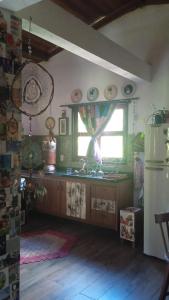 a kitchen with a counter and a window and a refrigerator at Loft Jardim Imbassai in Imbassai