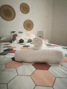 a bed with a white towel on top of it at La casita de Lyra in Granada