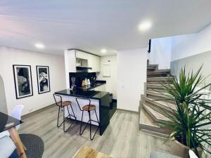 eine Küche und ein Wohnzimmer mit einer Bar und einer Treppe in der Unterkunft Elegant Palace in Parque 93 in Bogotá
