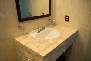 ein Badezimmer mit einem Marmorwaschbecken und einem Spiegel in der Unterkunft Hotel Boutique Sacramento in Bernal