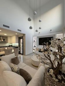 un soggiorno con un divano bianco e un albero di Villa Moderna con Piscina a Daya Vieja
