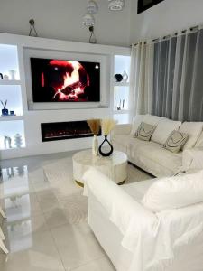 a living room with white furniture and a fireplace at Villa Moderna con Piscina in Daya Vieja
