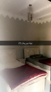 a bedroom with two bunk beds with a writing on the wall at منتجع السرايا السياحي in Al Qā‘id