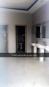 a bathroom with two sinks and a toilet at منتجع السرايا السياحي in Al Qā‘id