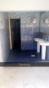 a blue tiled bathroom with a sink and a mirror at منتجع السرايا السياحي in Al Qā‘id