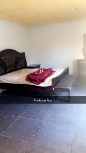 a bed with a red blanket on it in a room at منتجع السرايا السياحي in Al Qā‘id