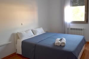 two white slippers sitting on top of a bed at Apartamento Exclusivo San Marcos in Manzanares