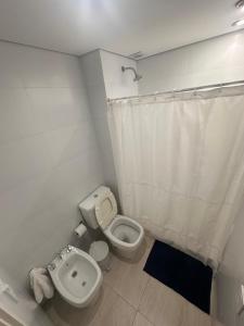 a bathroom with a toilet and a shower curtain at Apartamento Dock Trade Fisherton in Rosario