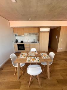 a dining room with a table and white chairs at Apartamento Dock Trade Fisherton in Rosario