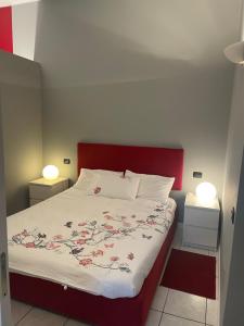 una camera con un grande letto con testiera rossa di Residenza Parco a Segrate