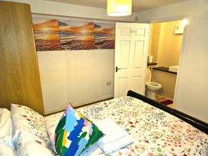 a bedroom with a bed and a painting on the wall at London O2 ARENA COOL BREEZE HOUSE in London