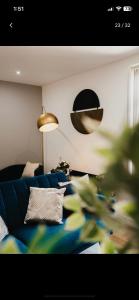 a living room with a blue couch and a lamp at Atlantic Suite - Wyndale Living - BHam JQ Lux 2 BR in Birmingham