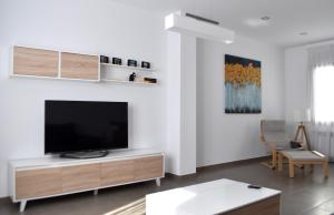 sala de estar con TV de pantalla plana en una pared blanca en Apartamento Exclusivo San Marcos, en Manzanares