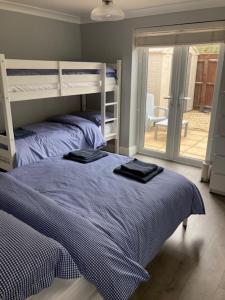 1 Schlafzimmer mit 2 Etagenbetten und einem Balkon in der Unterkunft Highcliffe Apartment with Parking in Christchurch