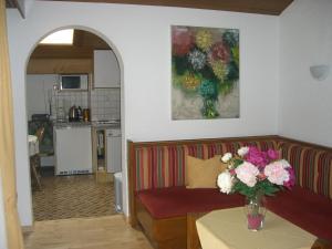 a living room with a couch and a vase of flowers on a table at Haus Ebner in Vandans