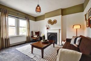 un soggiorno con divano e tavolo di Autumn Loft Wyndale Living Malvern Hills - Free Parking a Great Malvern